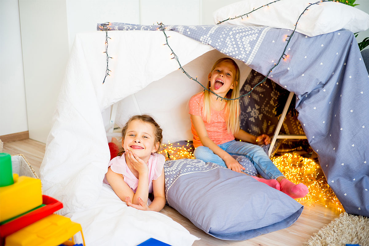 two girls in a blanket fort sleepover