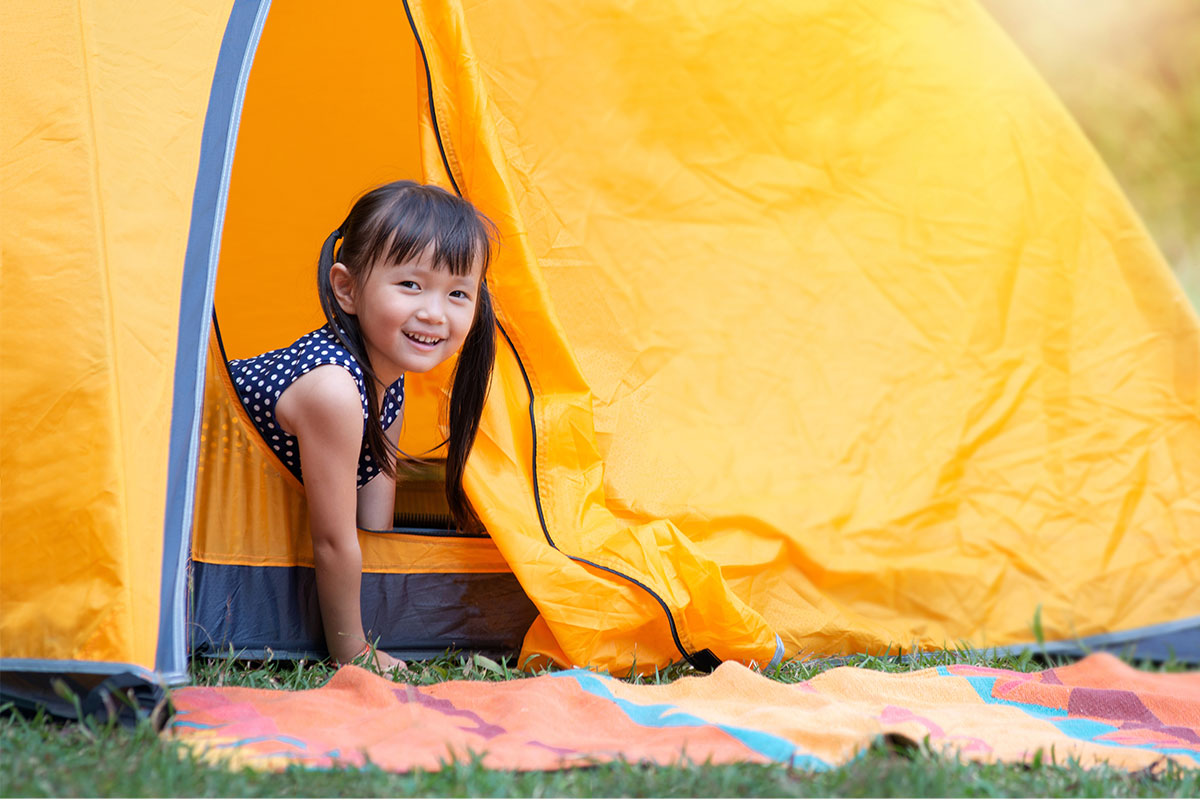 girl crawling out of orange tent