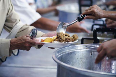 person receiving food in a cafeteria line