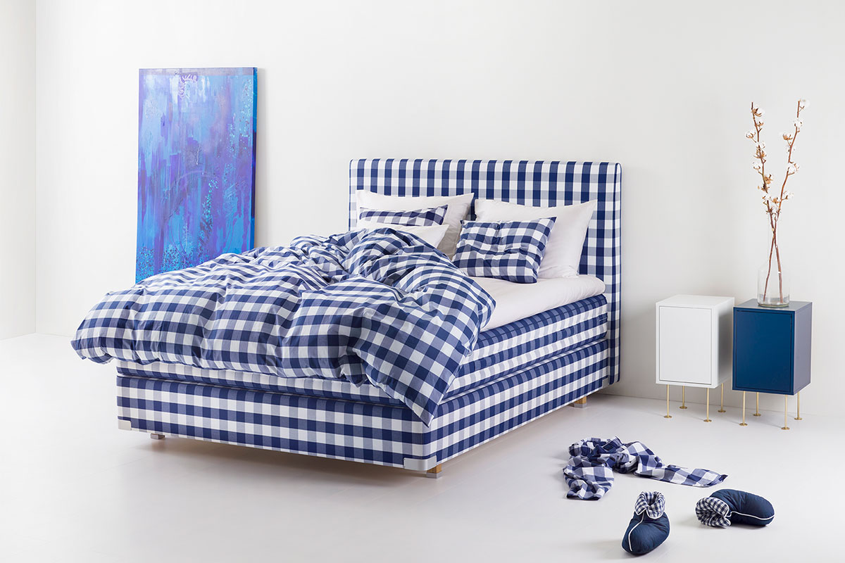 blue bed with blue painting in front of white walls