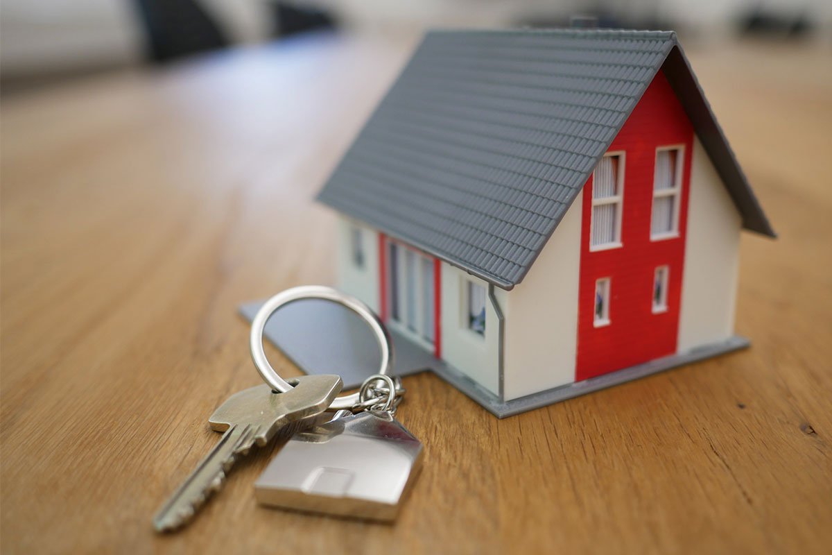 a miniature house next to a set of keys