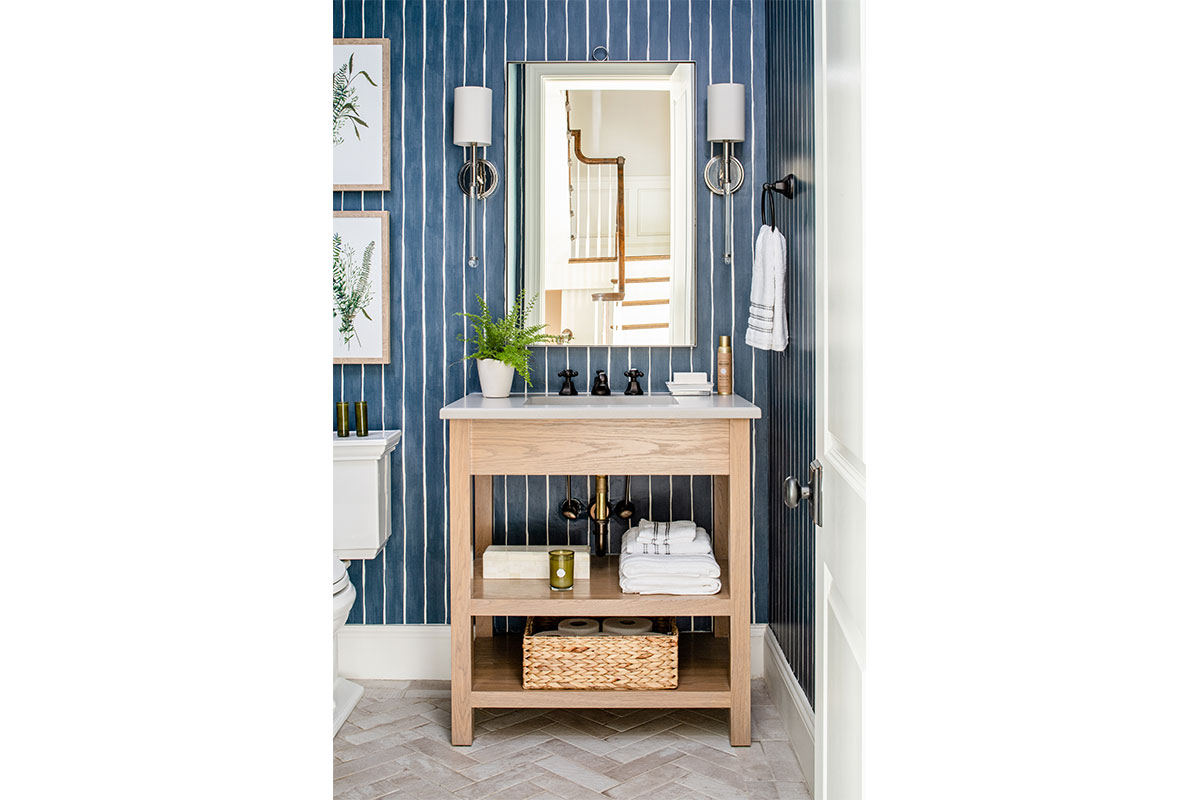 powder room with light wooden sink and mirror and blue striped wallpaper