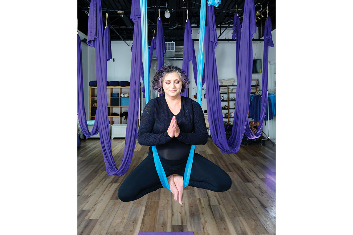woman hanging from aerial yoga silk blue and purple in loudoun county
