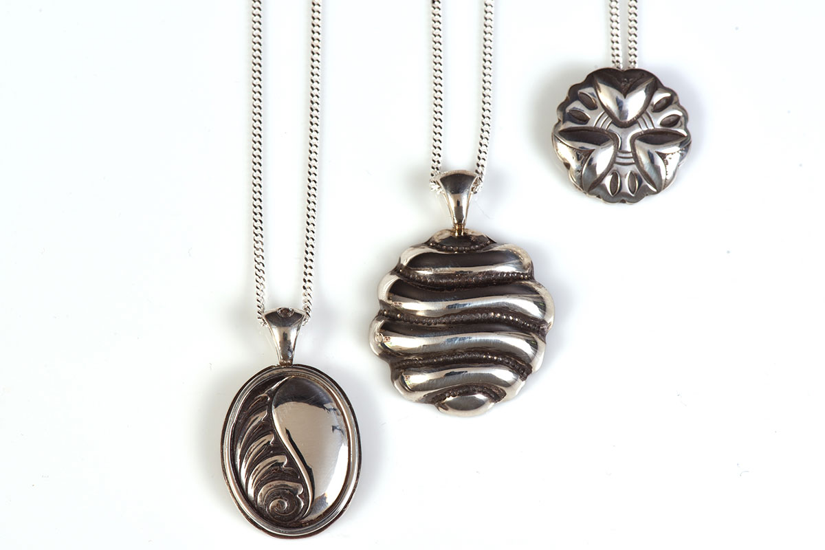 three silver pendants