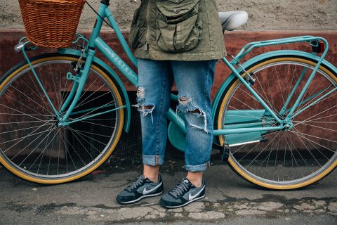 woman standing on blue bike