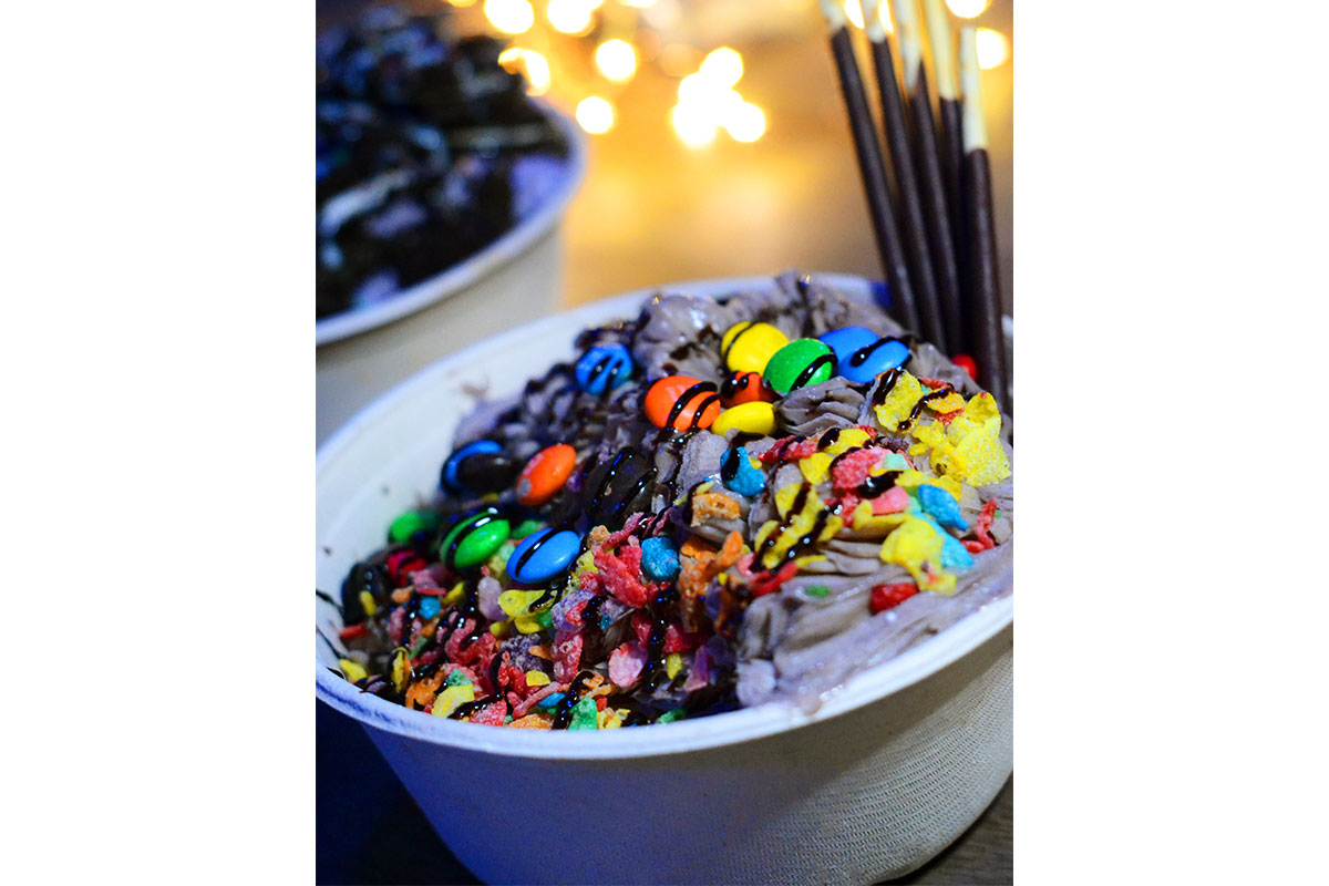 bowl of ice cream topped with mnms and chocolate syrup