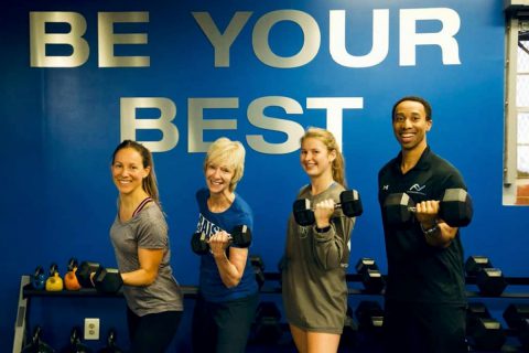 four people in front of wall that says be your best