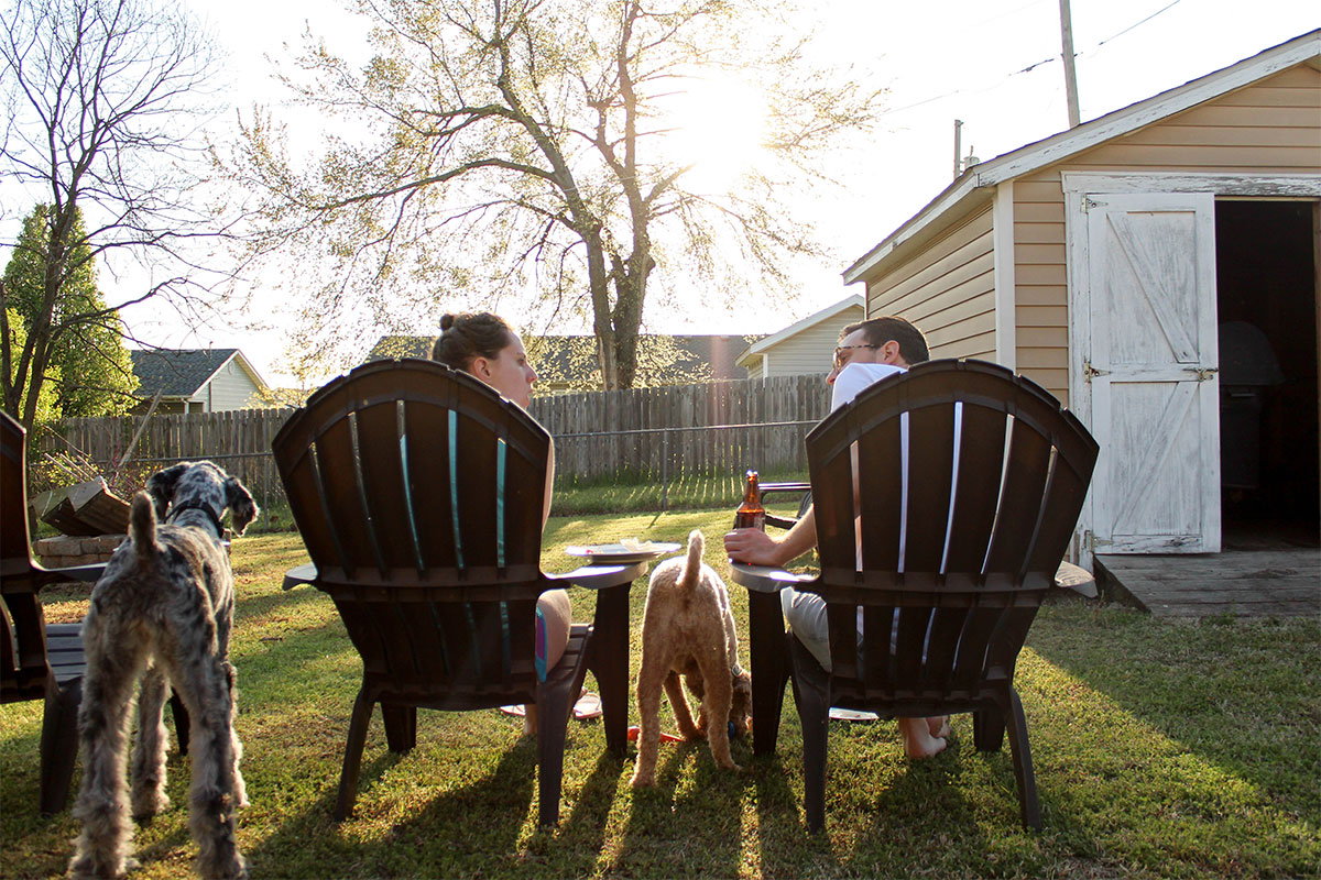 couple sitting in backyard with their dogs