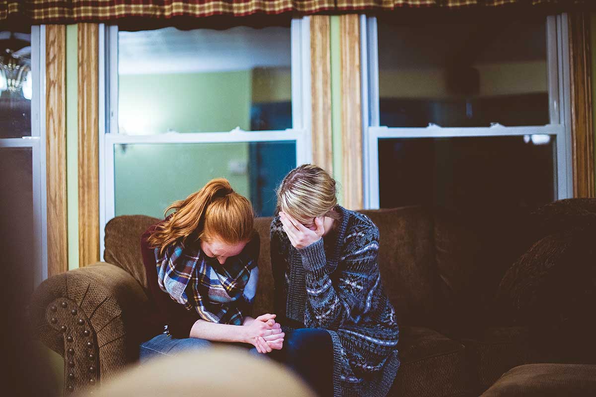 two women crying in living room with red and gray hair