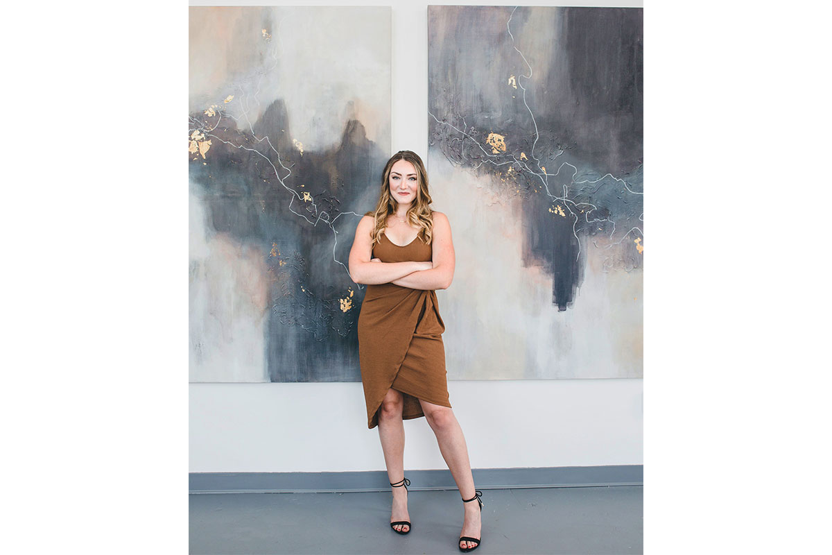 woman in brown dress in front of paintings