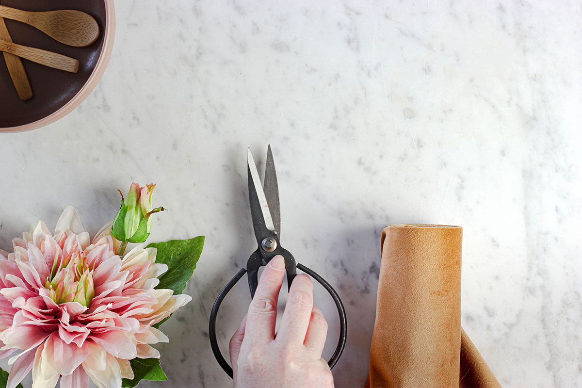 hand holding scissors to start arranging flowers