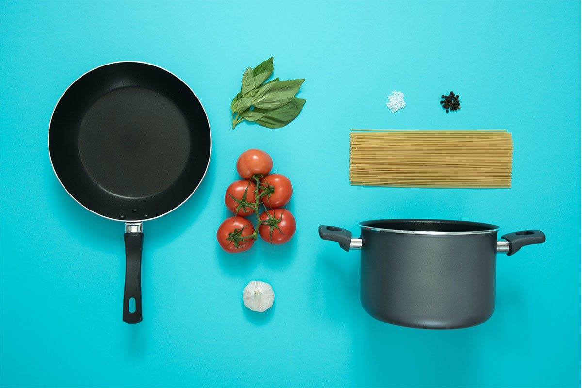a pot and pan and pasta ingredients on a blue background