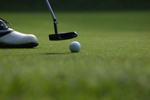 golfer on course putting the ball