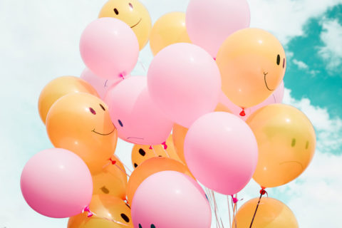 orange and pink balloons with smiley faces on them