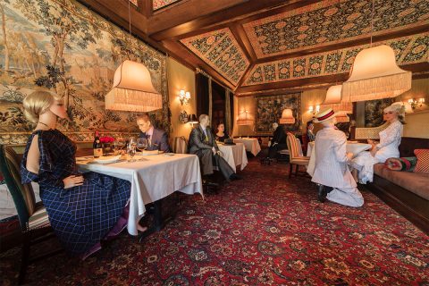 mannequins sitting in dining room at the inn at little washington