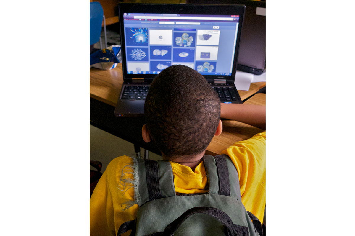 boy on computer with backpack