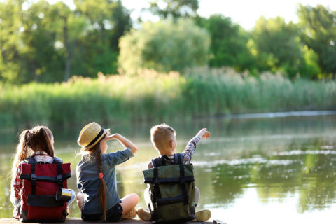 three kids looking out over the water