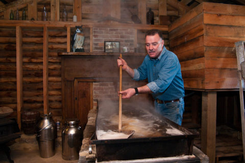 man in denim shirt making maple syrup in virginia