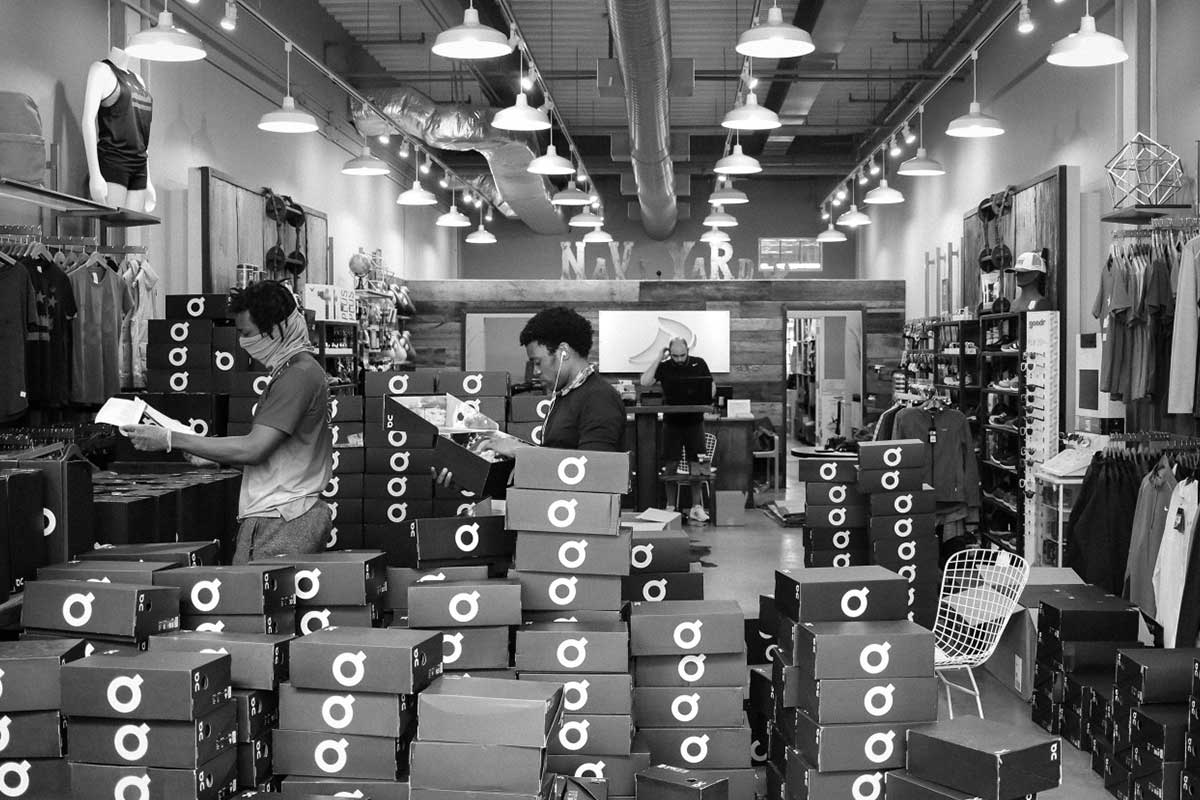 men standing in running store with running shoe boxes black and white