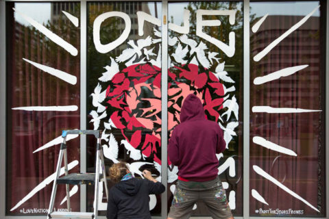 people painting a window