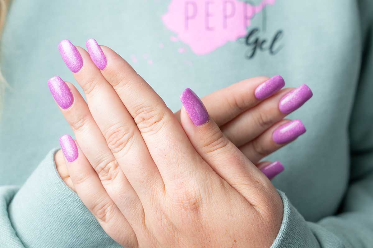 two hands with pink sparkly nail polish by peppi gels