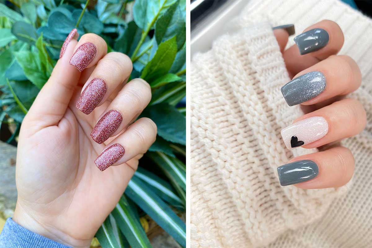 two hands with painted nails one with orange sparkly nails in front of green plant and other with gray and pink nails in front of white sweater