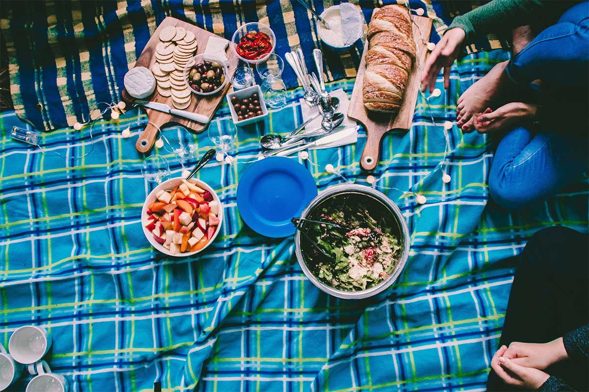 picnic blanket blue and green with food bread and salad and cheese and crackers