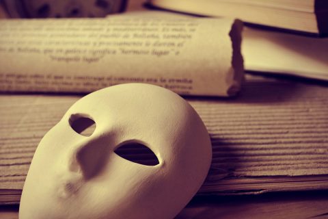 theater mask on top of notes