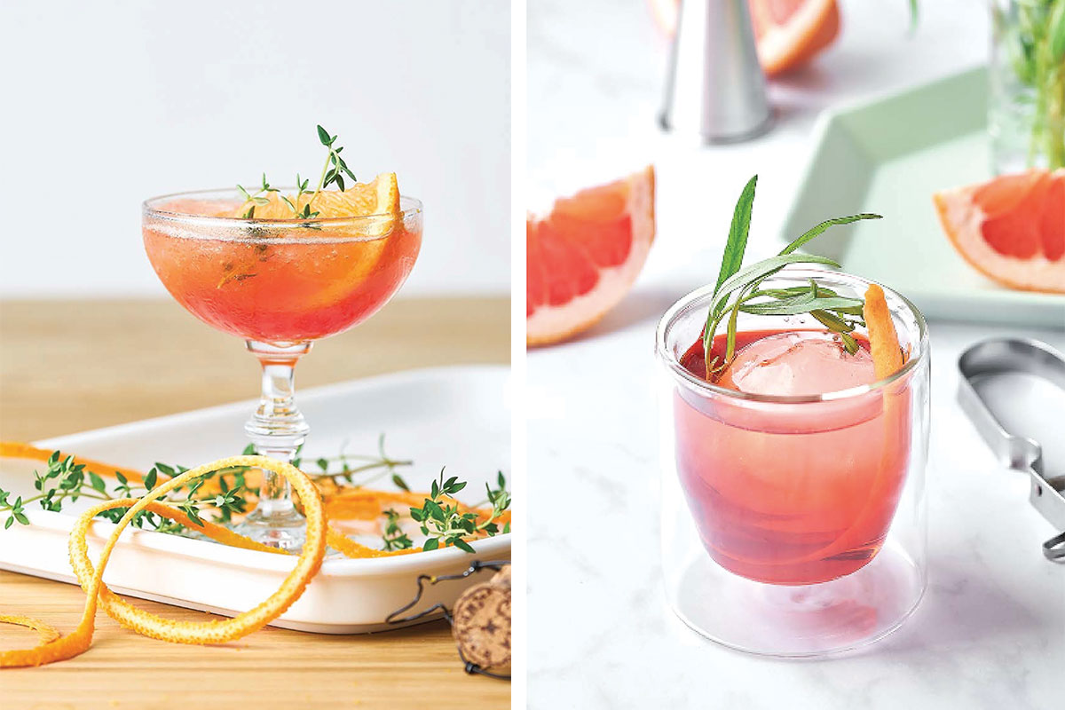 two cocktails with herbs on top