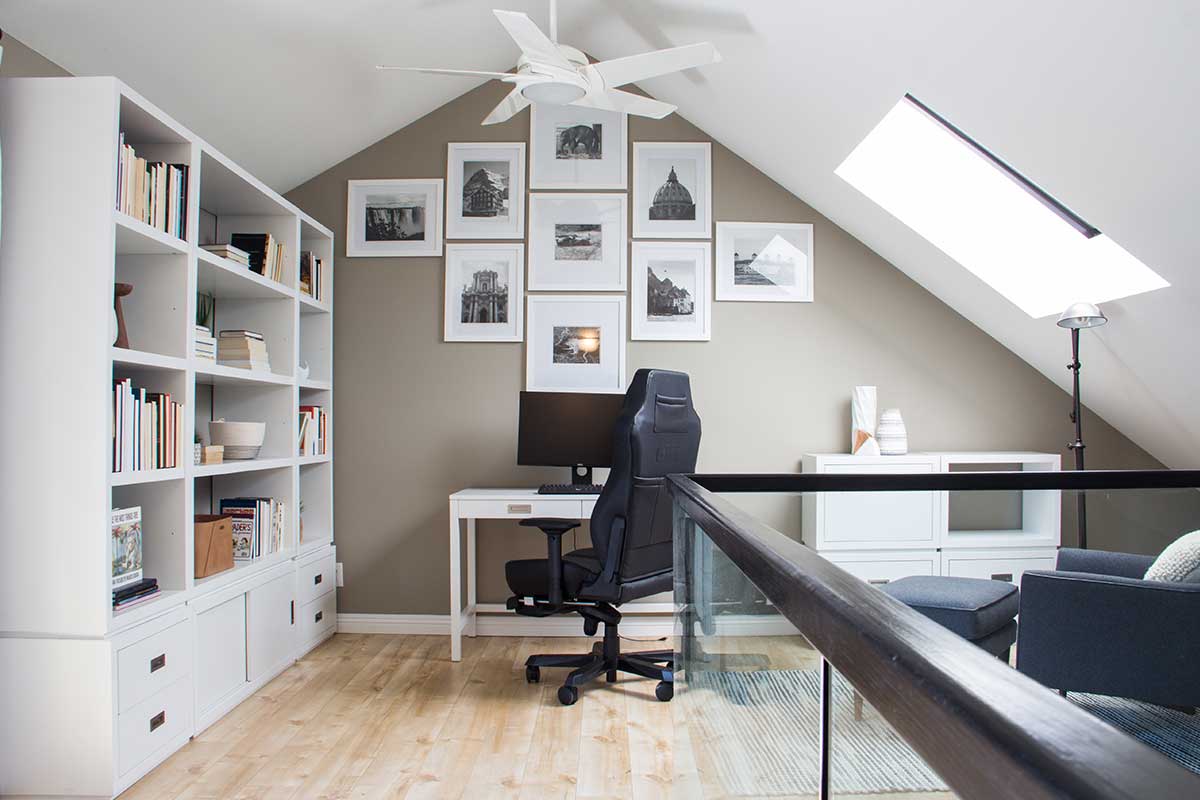 large work from home office with white bookshelf and skylight