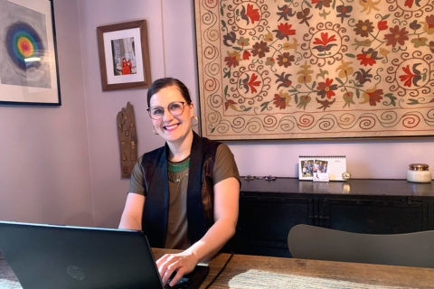 woman at her desk with hands on computer