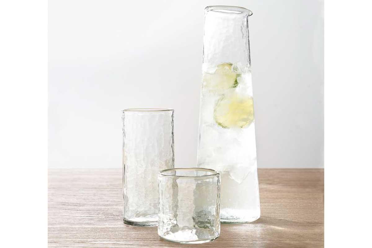 glass pitcher with wooden table and glass highball glass and old fashioned glass