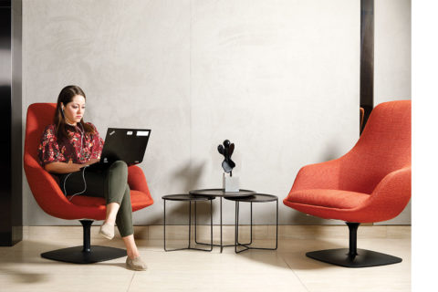 woman sitting in red chair with lap top