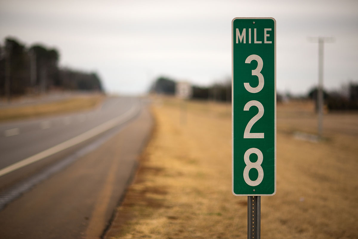 mile marker with green sign that says 328