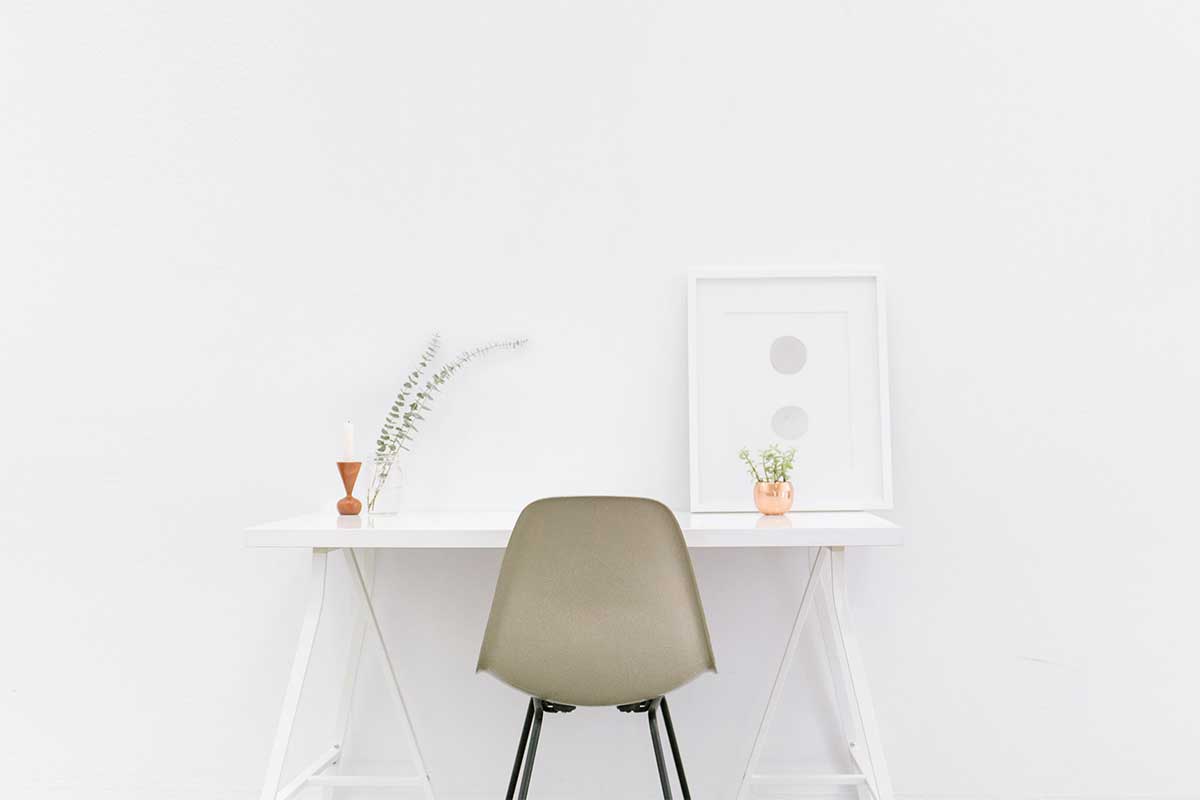 white desk with gray chair and little plants