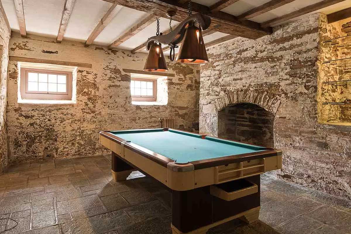 basement billiards pool room with stone walls