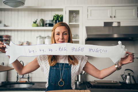 Christina tosi in overalls holding a sign
