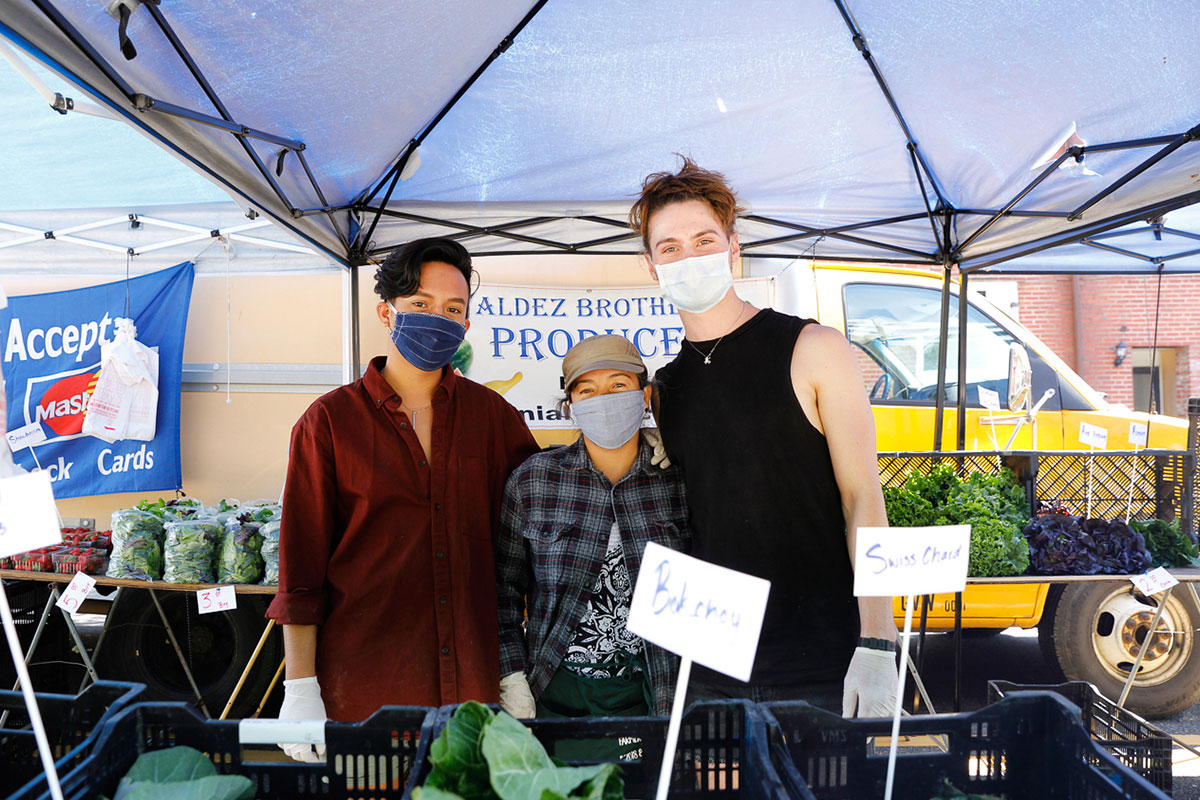 people working at farmers market with masks