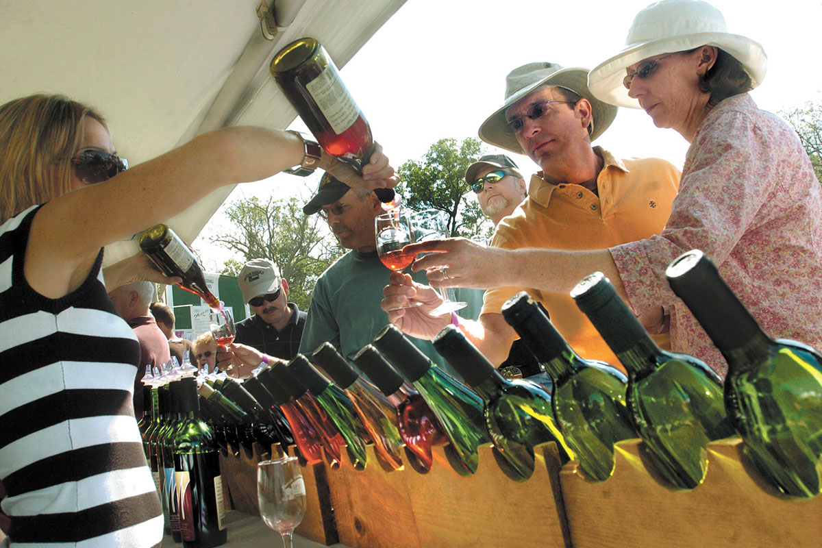 wine bottles being poured into people's glasses