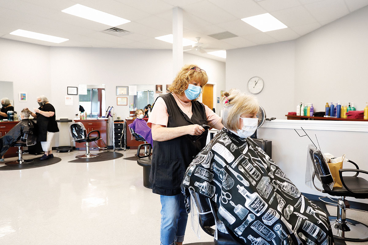 woman getting hair cut, both people wearing masks