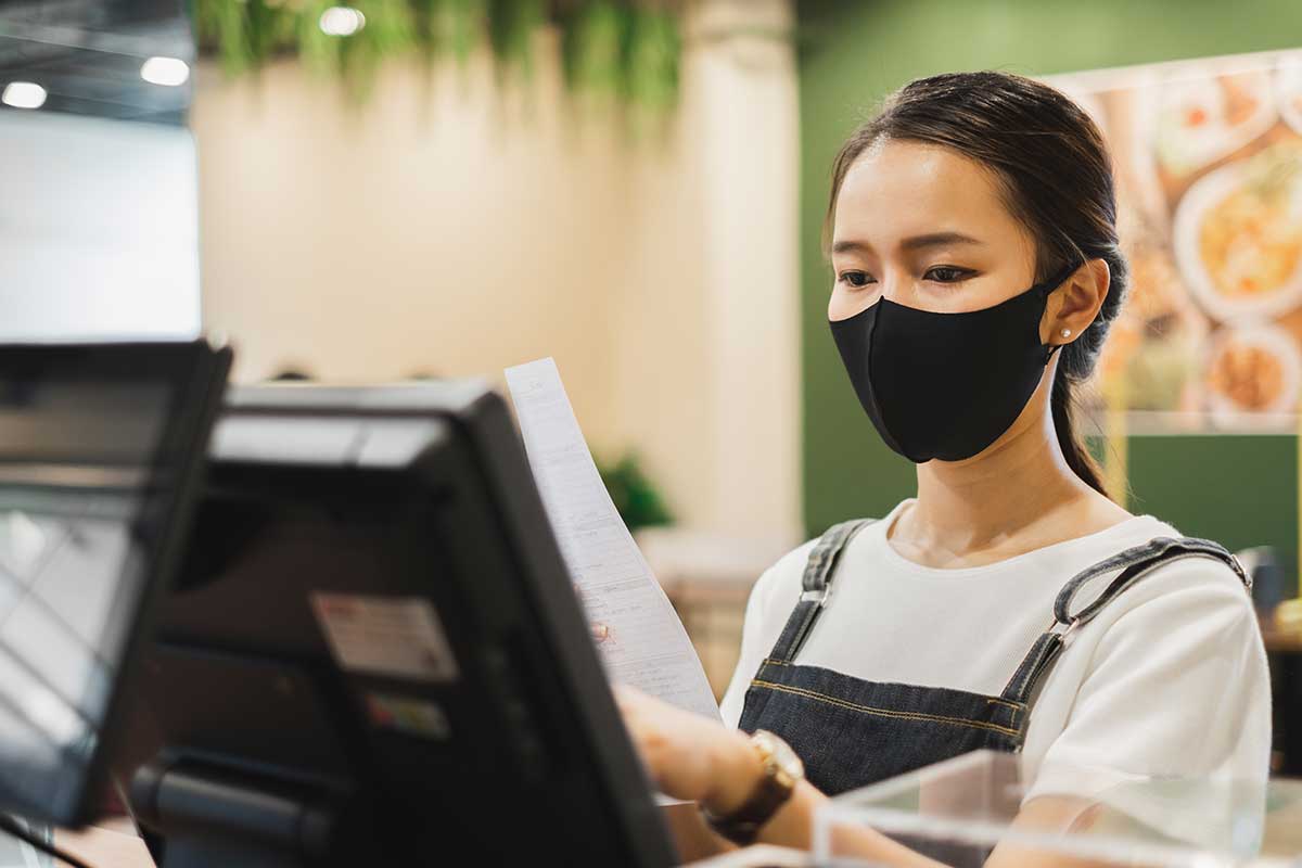woman with mask using cash register