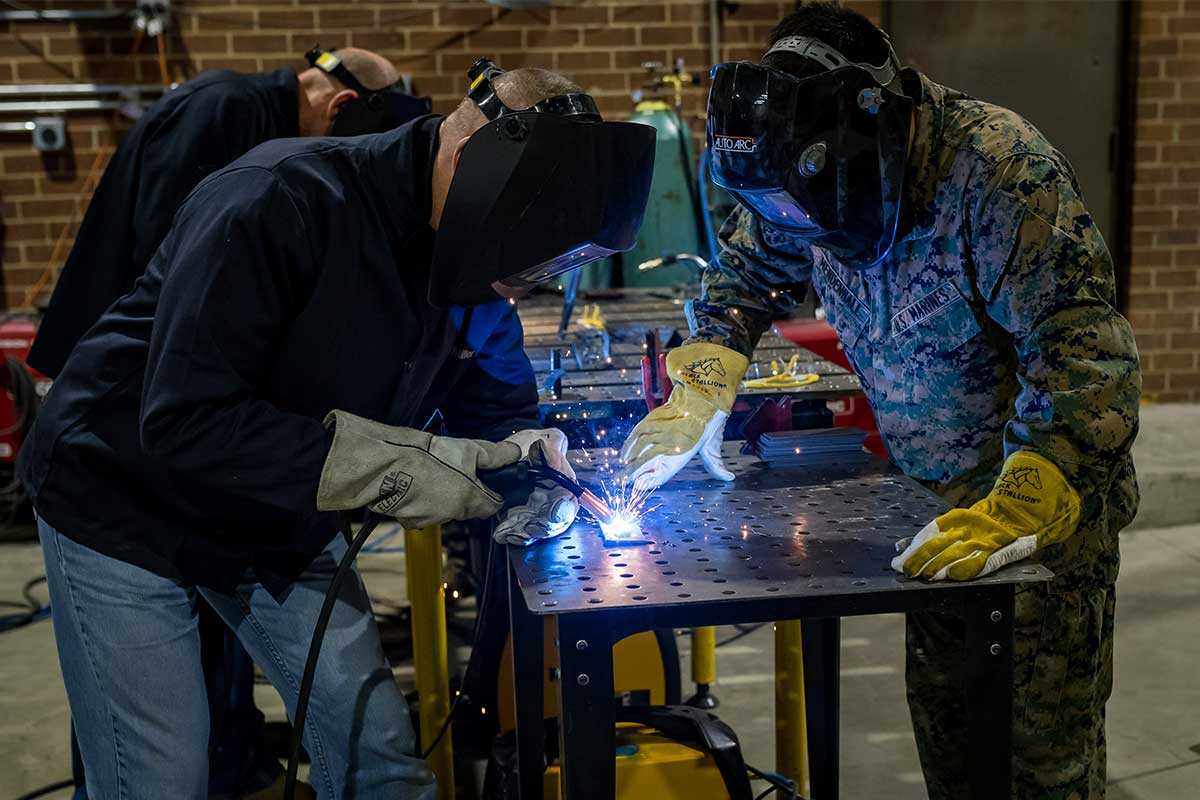 two people welding with masks on