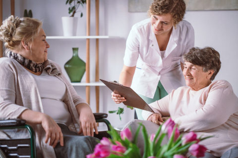 elderly couple with nurse in senior living home