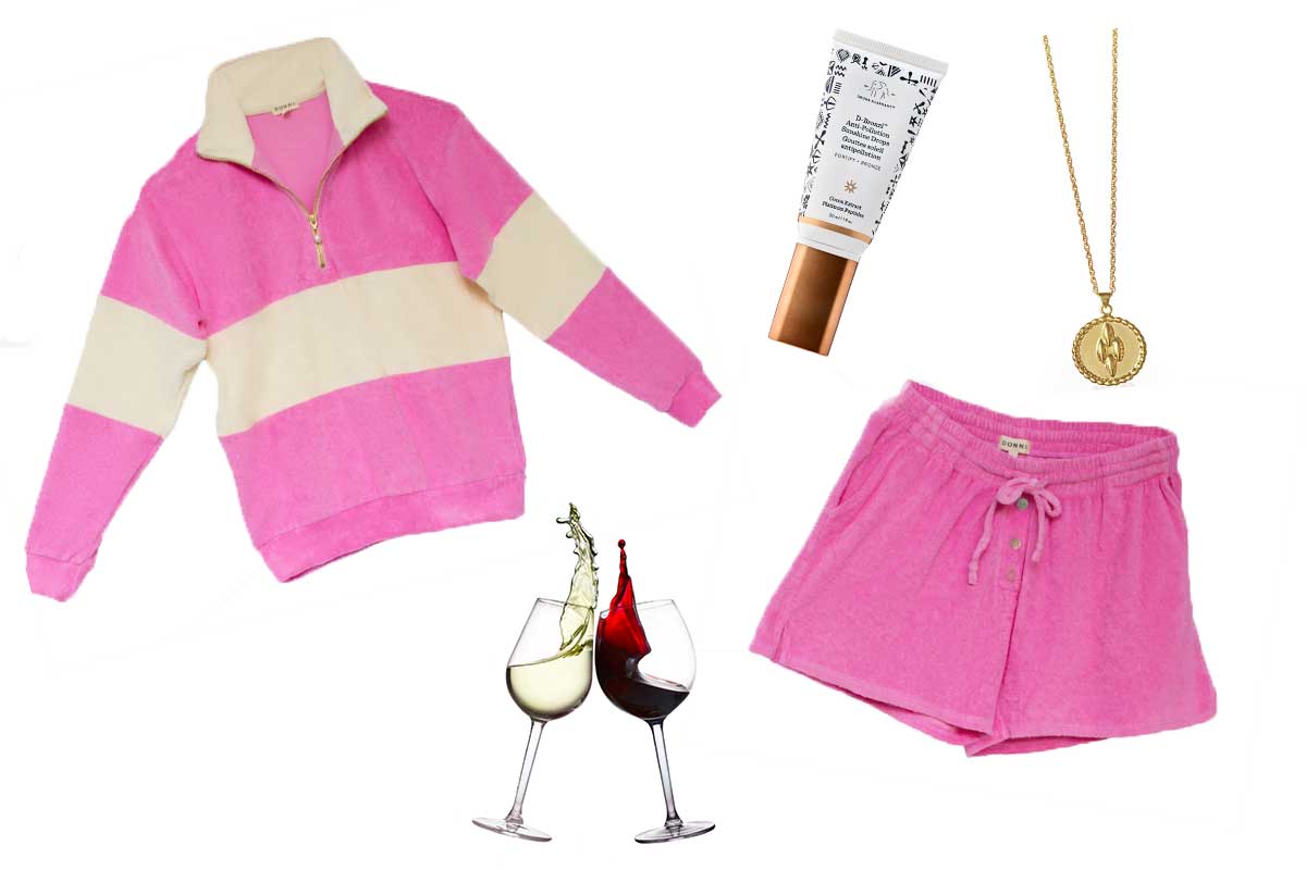 pink sweatshirt with shorts and bronzer and gold necklace and wine glasses