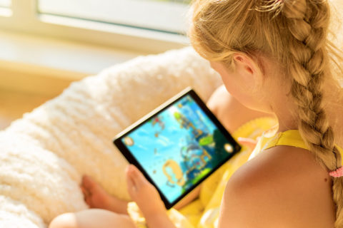 young girl with hair braided playing video games