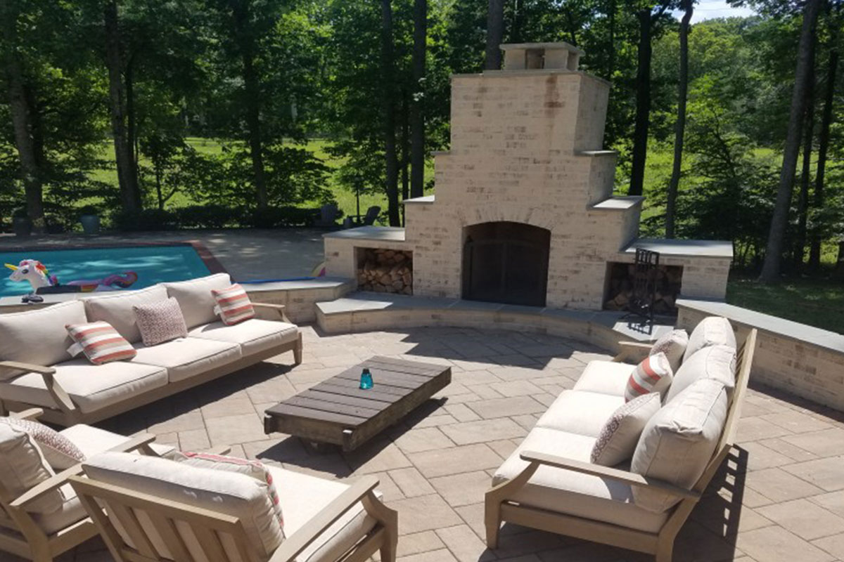 outdoor lounge area with fireplace and pool on the left
