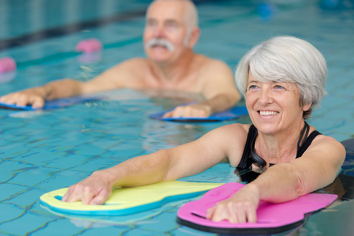 older couple doing water aerobics in pool