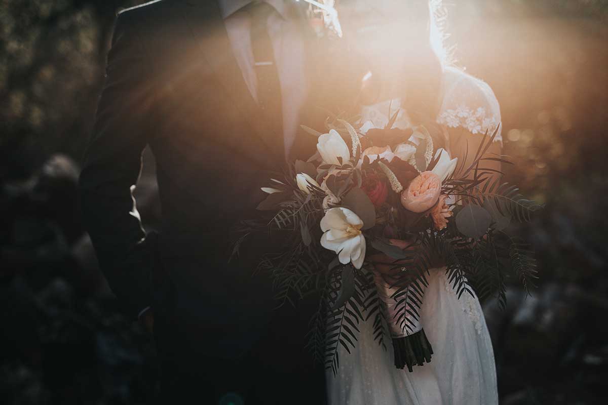wedding couple with white dress and black suit with large flower bouquet