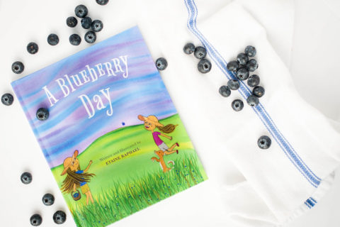 a blueberry day book cover near a spilled bags of blueberries