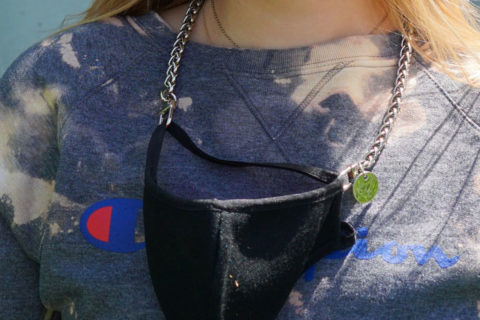 silver chain holding black face mask